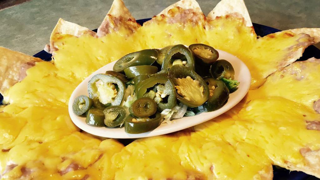 Bean & Cheese Nachos · Crispy tortilla chips topped with refried beans and melted cheese, with jalapeños on the side.