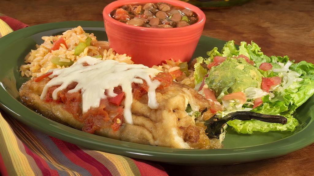 Chile Relleno · A fried poblano pepper stuffed with Monterrey jack cheese and topped with salsa ranchera. Served with guacamole salad and charro beans on the side.