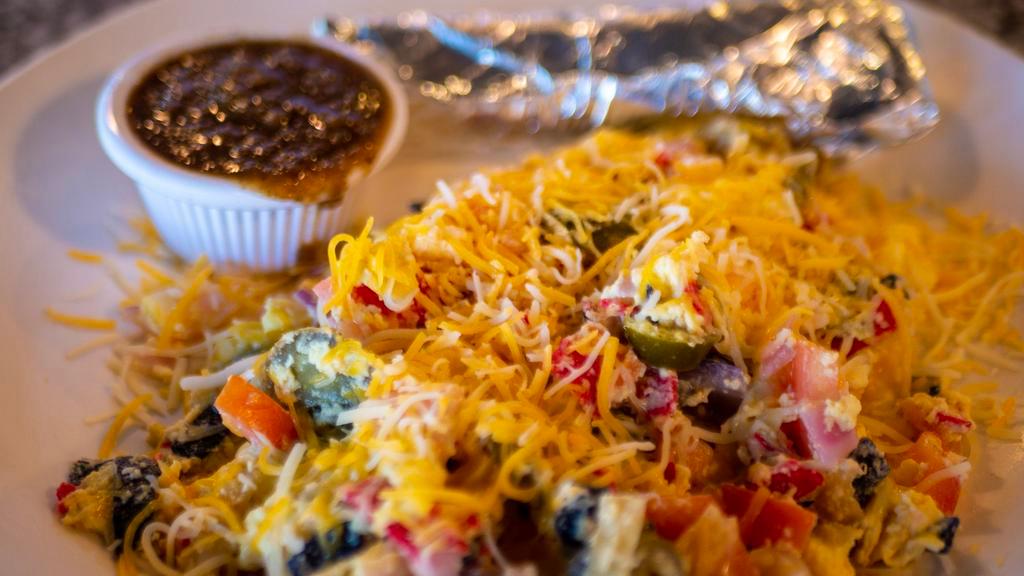 Migas · Scrambled eggs mixed with tortilla strips, jalapeños, tomatoes, onions, and aged cheddar. Served with black beans, hash browns, a side of our home-made salsa and your choice of corn or flour tortillas.