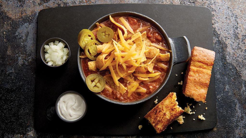 Firehouse Beef Chili · Topped with sharp cheddar cheese and served with grilled jalapeño cornbread, red onions, fresh jalapeños, and sour cream on the side.