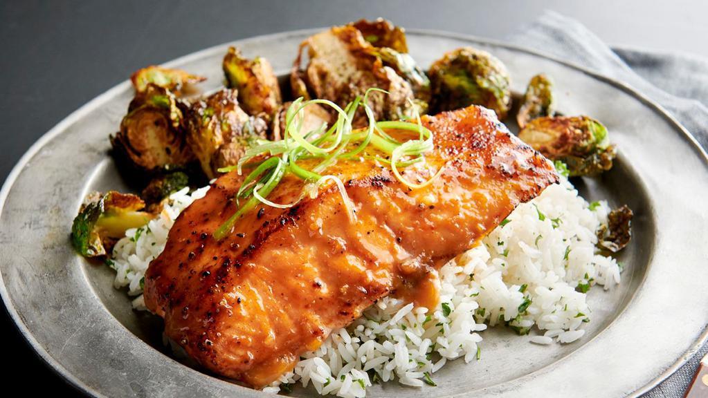 Miso Glazed Salmon · Marinated and grilled Atlantic salmon fillet topped with a sweet and savory miso glaze. Served with cilantro-lime rice and crispy brussels sprouts.