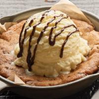 Gooey Chocolate Chip Cookie · Fresh baked and topped with vanilla ice cream and chocolate drizzle.