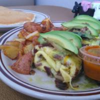Spicy Poblano Country Omelette · Shredded beef, roasted poblanos, roasted onions, cheese, spicy poblano sauce topped with avo...