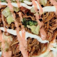 Beef Patacones · Shredded beef, mozzarella, and pico de gallo, avocado, house sauce, and pink sauce over frie...