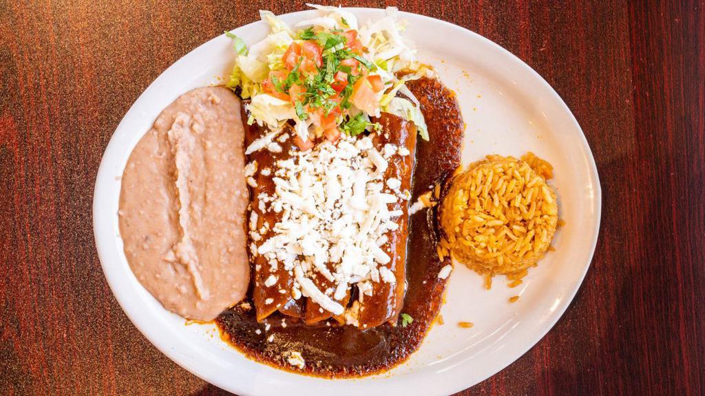 Enchiladas De Mole · THREE CHICKEN ENCHILADAS ON CORN TORTILLA, TOPPED WITH MOLE SAUCE AND QUESO FRESCO. SERVED WITH RICE, REFRIED BEANS AND TWO TORTILLAS ON THE SIDE.