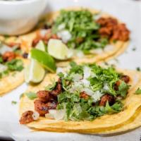 Taco Al Pastor · Three corn tortillas filled with tender marinated pork. Served with onions, cilantro. Mexica...