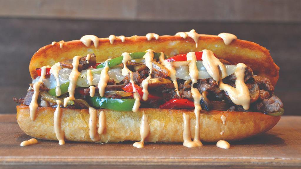 Original Beef Philly · Seasoned steak topped with onions, red and green peppers, mushrooms, Provolone cheese and white cheese sauce. Served on a traditional hoagie roll.