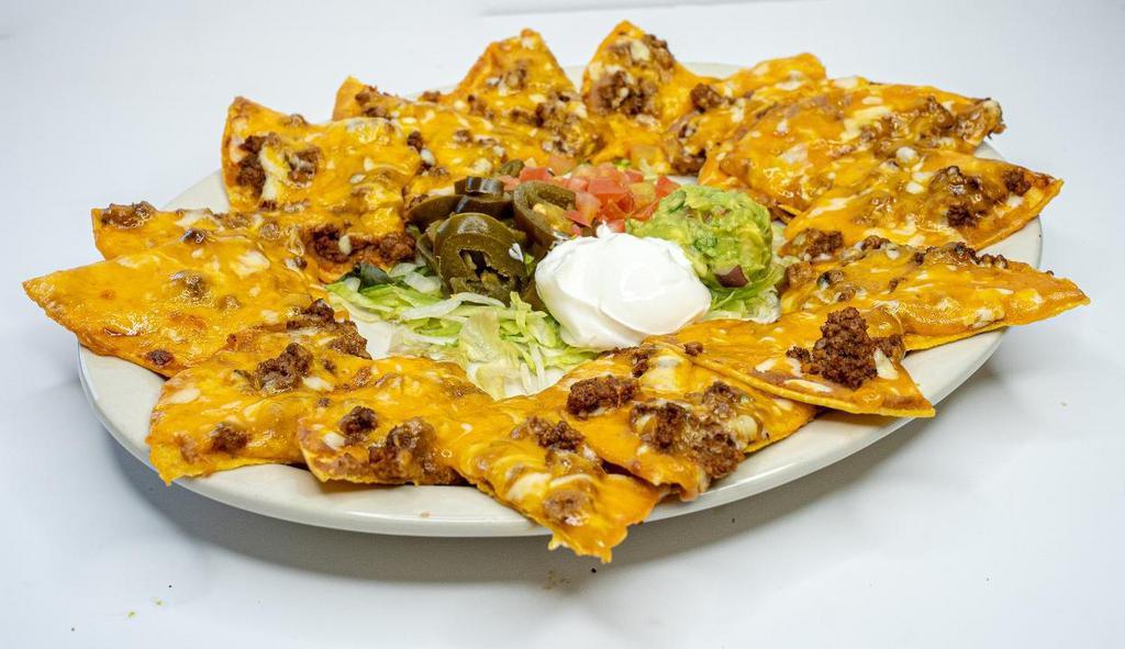 Tx Style Nachos -  Large · Crispy tostadas covered with refried beans, your choice of ground beef or grilled chicken, melted blend of cheddae and Swiss cheeses, served with pico de gallo, sour cream, guacamole, jalapenos, and salsa on a bed of lettuce.