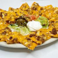 Tx Style Nachos - Small · Crispy tostadas covered with refried beans, your choice of ground beef or grilled chicken, m...
