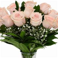 Unforgettable Arrangement (Pink) · A Dozen Pink Roses with greenery and filler in a clear vase.