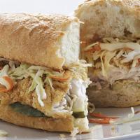 Catfish Poboy · Fried Catfish resting on French bread dressed with lettuce, tomato and remoulade served with...
