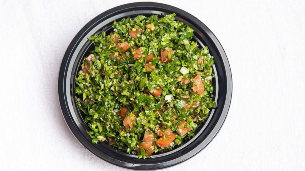 Tabbouleh · Vegan. A traditional Lebanese salad containing parsley, tomatoes, mint, spring onion, crushed wheat (bulgur), olive oil, lemon juice, and salt and pepper.