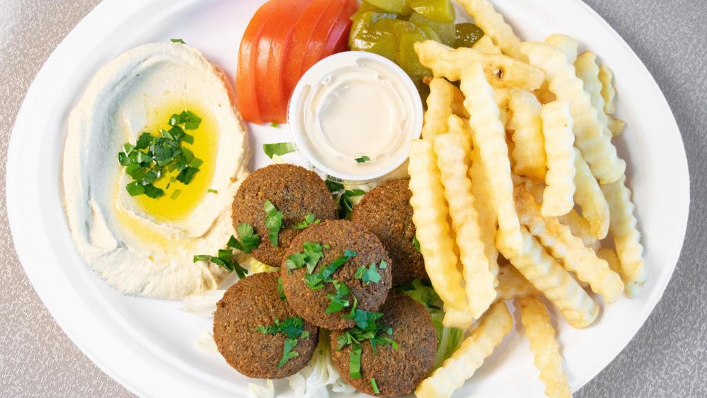 Falafel Platter · Vegan. A platter of falafel served with fries, bread, pickles, lettuce, tomato, parsley, traditional tahini sauce, and hummus.Platter
