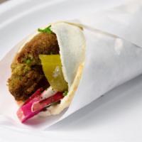 Falafel Sandwich  · Vegan. A wrapped falafel sandwich in bread with parsley, tomato, pickles, and traditional ta...