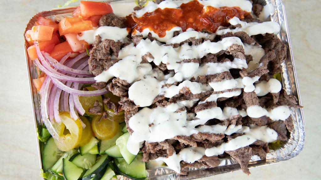 Lamb Shawarma Over Rice · Marinated lamb, thin sliced over spiced basmati rice and a side salad. Served with our white sauce and hot sauce.
