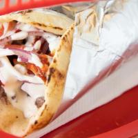 Lamb Shawarma Wrap · Marinated lamb, thin sliced wrapped in a pita bread with tomato, onions, and our white sauce...