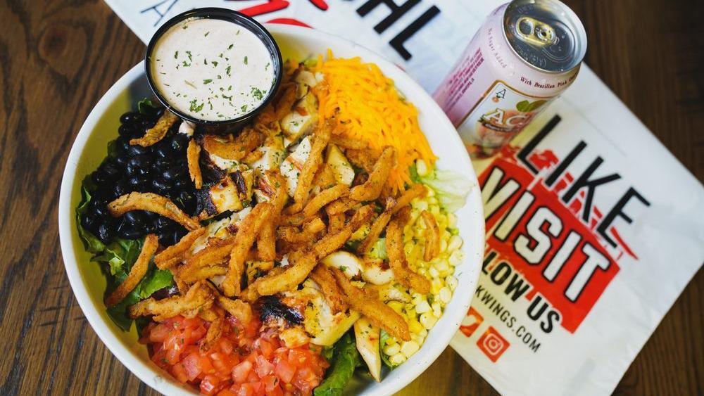 The Tejano · Greens, grilled chicken with onion strings, black beans, corn, tomato, cheese, and chipotle ranch.