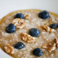 Bowl Of Oatmeal- · Topped With Walnuts And Fresh Blueberries. Naturally Sweetened With Local Honey