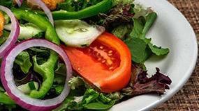 House Salad · Romaine lettuce, red onions, bell peppers, cucumbers, roma tomatoes, red cabbage, black oliv...