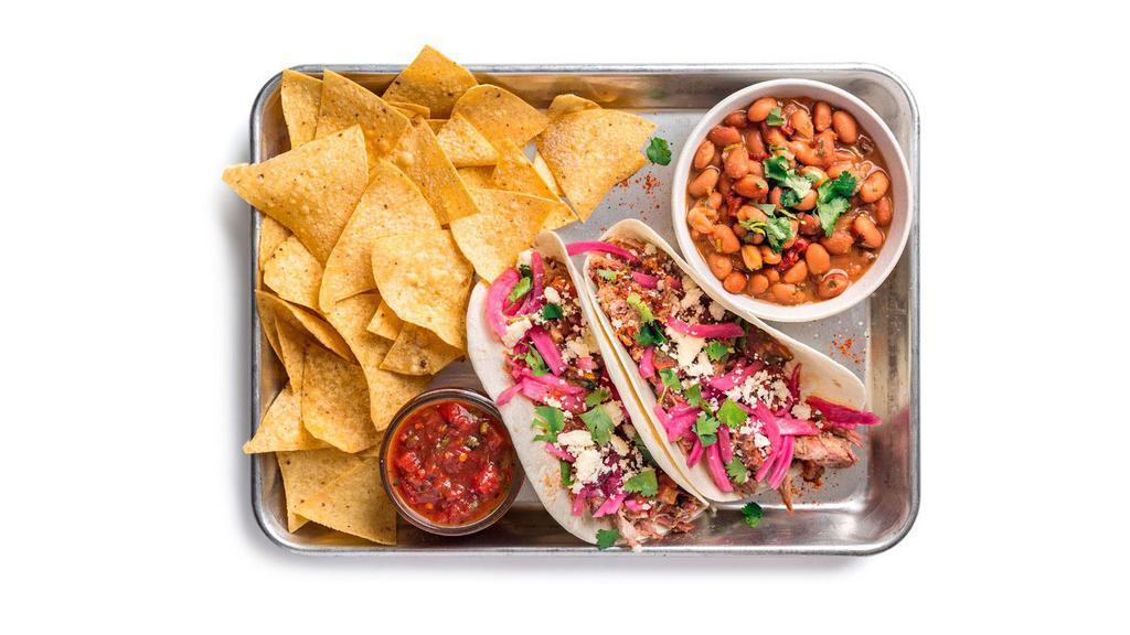 Cowboy Brisket Taco Plate · Two tacos (1 flavor) containing spicy brisket, pickled red onions, and salsa picante. Served with ranchero beans and chips & salsa.