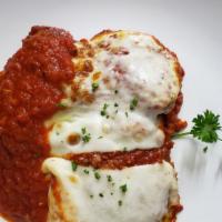 Chicken Parmigiana · Breaded chicken breast topped with mozzarella cheese and tomato sauce. served with a side of...