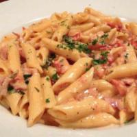 Penne Ala Vodka · Sautéed with prosciutto ham, fresh basil, garlic and fresh tomatoes in a cream sauce with a ...