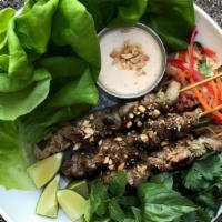 Charred Pork Skewers · lemongrass marinated pork, lettuce wraps, green. papaya salad, cashew crema, thai basil, cil...