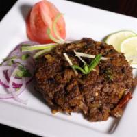 Mutton Sukka Varuval · Tender boneless goat cubes pan roasted with onion and house chettinad spices.