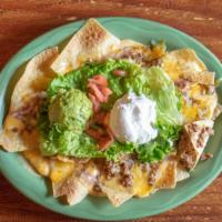 Nachos · Platter of chips topped with cheese, lettuce, tomato, guacamole, beans, sour cream, and jala...