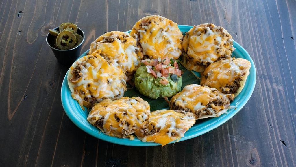 Ground Beef Nacho · Seasoned ground beef atop refried beans & mixed cheese melted to perfection. Served with a side of guacamole, pico de gallo & jalapeños.