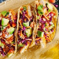 Ginger Lime Fish Tacos · Three open-faced, fried tilapia tacos served on char-grilled corn tortillas with fresh has a...