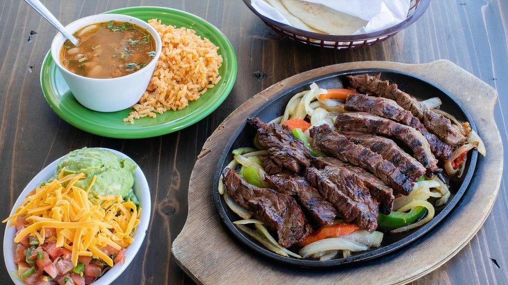 Full Pound Steak Fajitas · Mesquite grilled fajitas sizzling atop grilled onions & bell peppers. Served with guacamole, pico de gallo, cheese, Spanish rice & charro beans. Serves 3-4 people.
