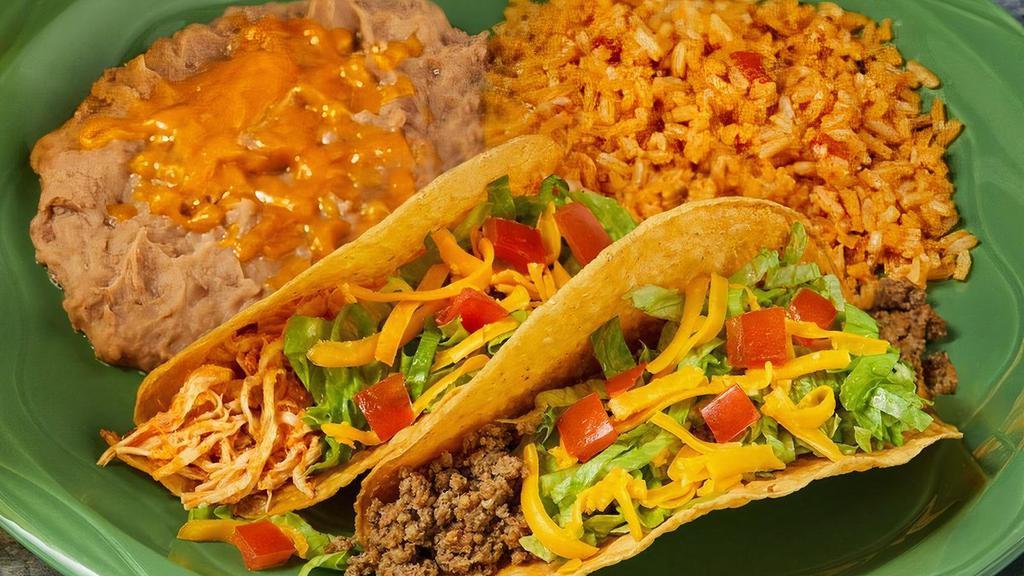 Og Tacos · Two pulled chicken or ground beef tacos in a crispy or soft tortilla topped with lettuce, tomato & cheese. Served with Spanish rice & frijoles refritos.