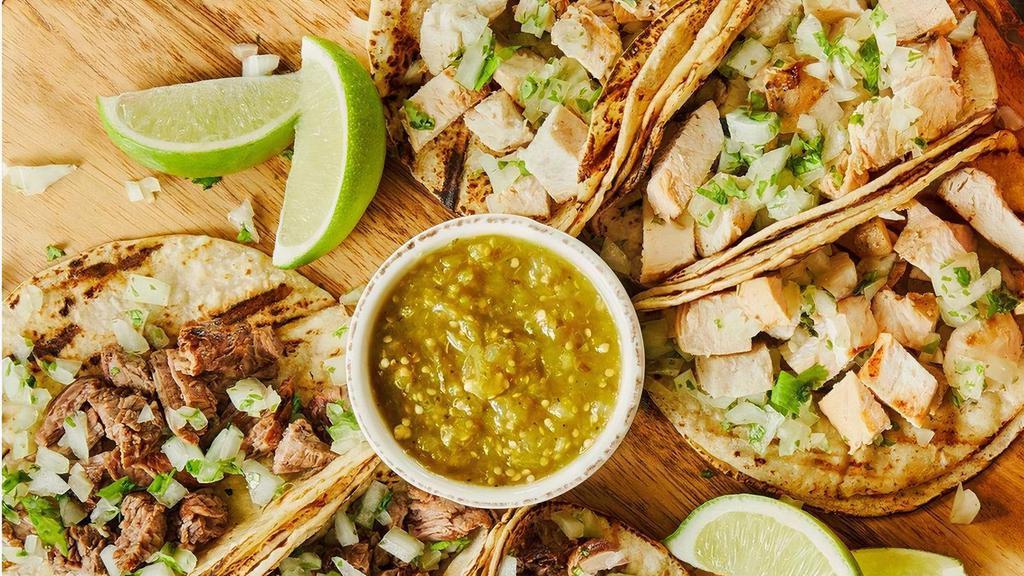 Augie'S Street Tacos · Combination of mesquite grilled fajita chicken & steak atop six grilled mini corn tortillas topped with fresh cilantro, onions & a side of warm salsa verde.