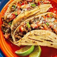 Impossible Tacos · Two corn tortillas stuffed with plant-based impossible taco meat. Topped with pico de gallo,...