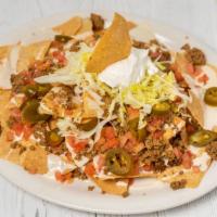 Nachos · A pile of tortilla chips topped with shredded lettuce, tomatoes, sour cream, jalapeños, ques...