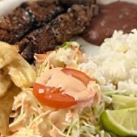 Honduran Style Grilled Steak (Carne Asada) · Served with rice, refried beans, cheese, cabbage salad, pico de gallo, fried banana slices o...