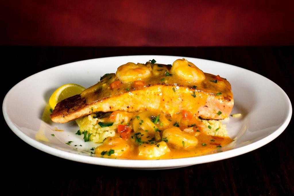 Decadent Salmon · Pan-seared salmon fillet topped with sautéed shrimp, mushrooms & red peppers tossed in a lobster cream sauce. Served on seasoned rice. Choice of one additional scratch made side.