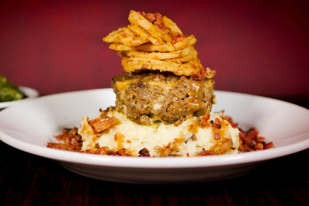 Mile High Meatloaf · Our spicy spin on a classic dish. Ground chuck, fresh onions, green peppers, jalapeños, herbs & spices. Topped with brown gravy, bacon & fried onion straws.