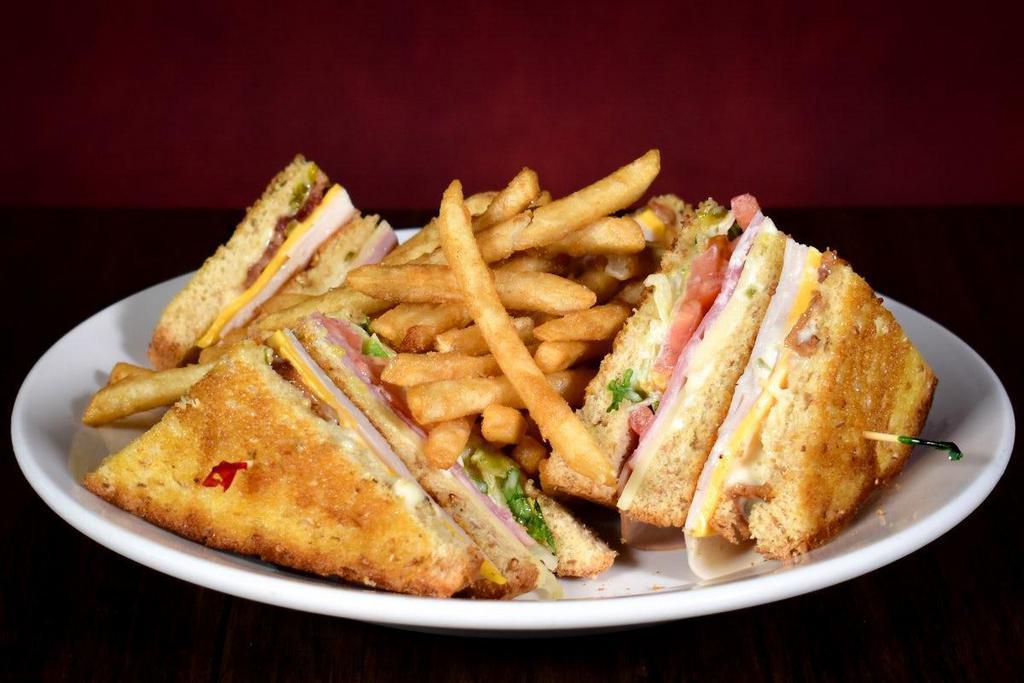 Traditional Club Sandwich · A triple-decker classic! Ham, turkey & bacon with American & jack cheese, lettuce, tomato & our house made club sauce on toasted wheatberry bread. Served with french fries.