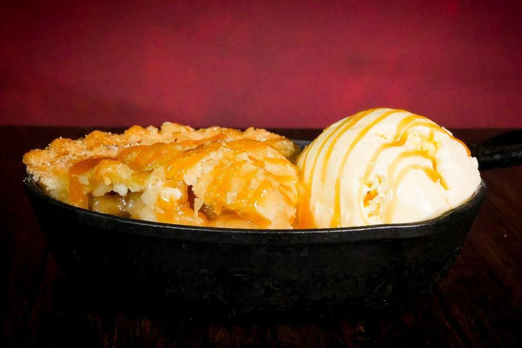 Apple Pie · Fresh baked warm apple pie served with vanilla ice cream, topped with caramel drizzle and sprinkled with cinnamon sugar.