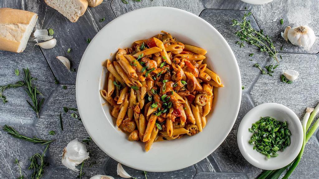 Jambalaya Pasta · Andouille sausage, chicken, shrimp and fish tossed in a spicy tomato cream sauce with penne pasta and veggies.