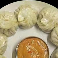 Chicken Momo · Steamed bun filling with ground chicken, served with roasted sesame seeds, peanuts and tomat...