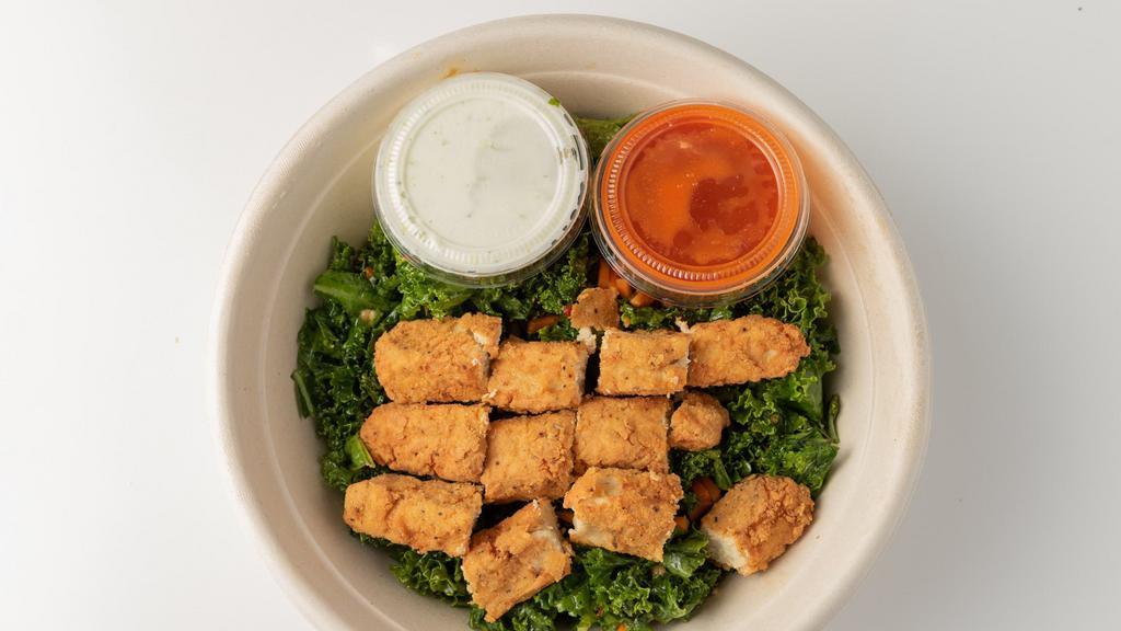 Buffalo Chik-N® Bowl · Our Buffalo CHIK-N® Wrap served as a bowl. Includes house made CHIK-N® tenders tossed in buffalo sauce, covered in poblano ranch,  topped with kale salad and served in a bowl.