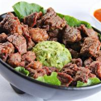 Chicharrón De Ribeye · Crunchy fried ribeye tips served on top of our delicious house guacamole. Serves 3-4.