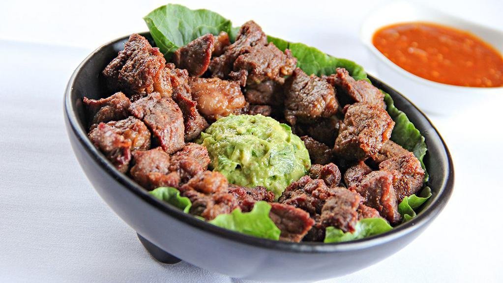 Chicharrón De Ribeye · Crunchy fried ribeye tips served on top of our delicious house guacamole. Serves 3-4.