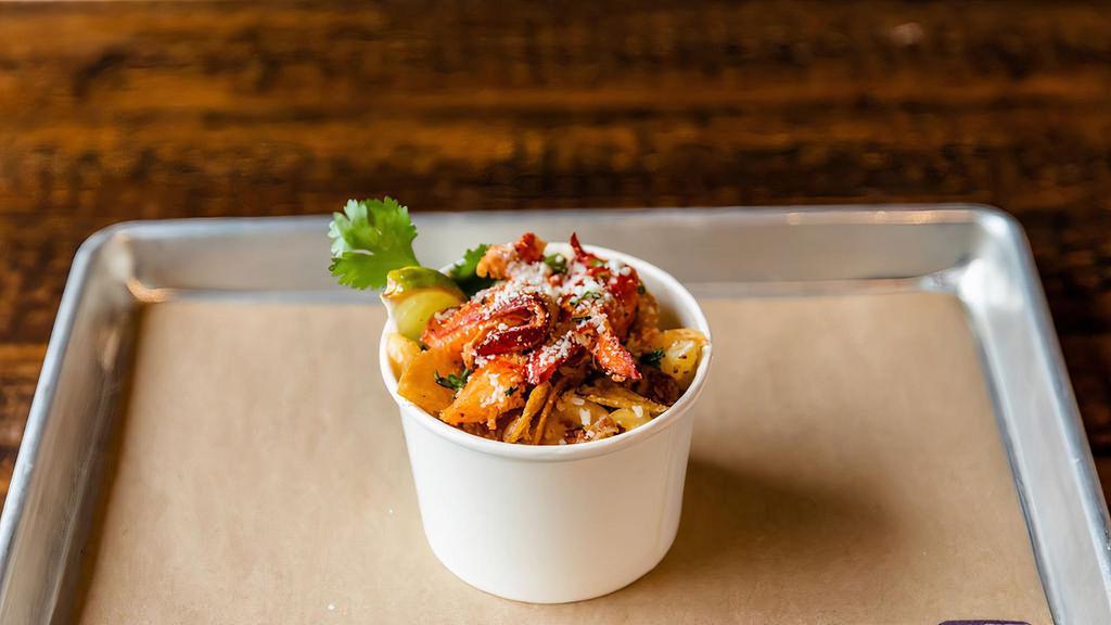 Lobster Mac · Cavatappi pasta, Creamy gouda cheese, Bacon, Crumbled Chips, Lobster, Cotija Cheese, Chives, Cilantro and Lime