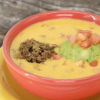 Regular Queso Compuesto · Our Chile Con Queso, topped with fresh guacamole and taco meat.