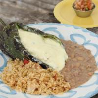Poblano Chicken · A large poblano pepper stuffed with seasoned shredded chicken and jack cheese, cooked over c...