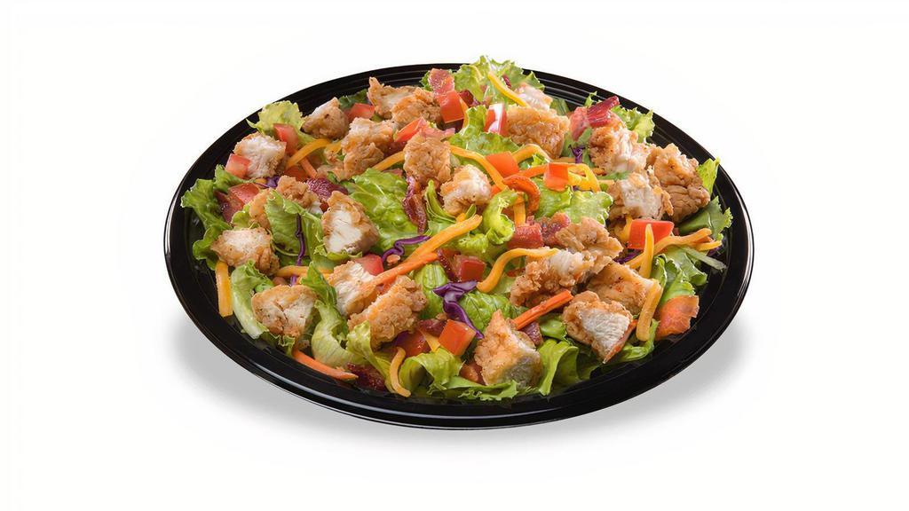 Crispy Chicken Salad · Our signature chicken strips, served hot and crispy, diced, and placed on a crisp blend of romaine and iceberg lettuce. Topped with diced tomatoes, cheddar cheese, and hand chopped hickory smoked bacon. Served with honey mustard. 520 Cal